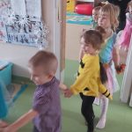 Dzieci w strojach karnawałowych bawią się w pociąg.