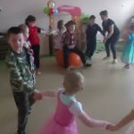 Dzieci w strojach karnawałowych tańczą w kółeczku