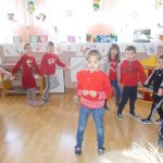 czworo dzieci w czerwonych bluzeczkach tańczy w rytm muzyki