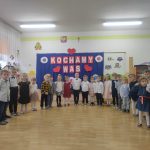 Dzieci ustawione w półkolu śpiewają piosenkę